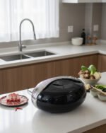 Modern sleek black insulated thermal hotpot casserole with metallic chrome accents on a kitchen counter with fresh hotpot ingredients