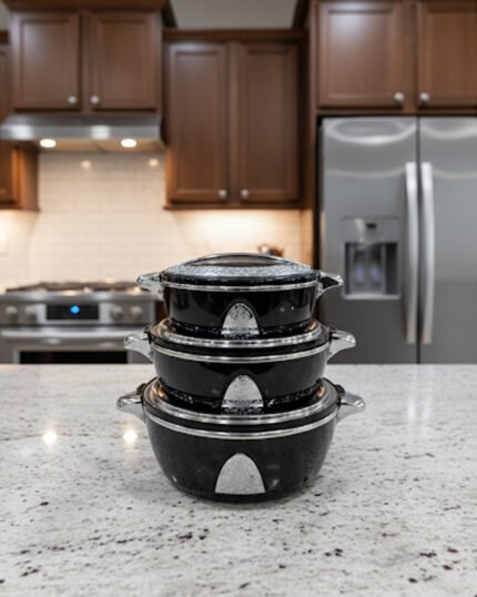Stacked 3-piece black insulated hot pot set with chrome silver accents on a marble kitchen countertop.