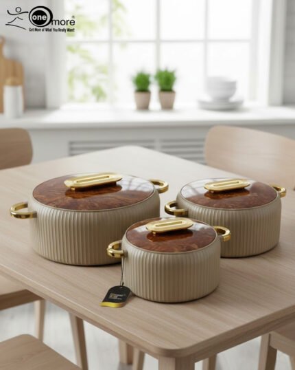 A professional studio shot of a set of three graduated-size insulated hotpots with gold handles, featuring a ribbed cream or grey body and decorative marble or wood-patterned lids, displayed on a kitchen countertop.