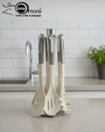 Luxury white marble-look cooking utensil set with rotating holder and rose gold accents. Includes spatula, spoon, and pasta server. Ideal kitchen decor centerpiece.