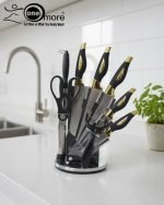 One More luxury 11-piece knife set in rotating stainless steel and clear acrylic block. Features black and gold accented handles, perfect as a modern kitchen centerpiece.