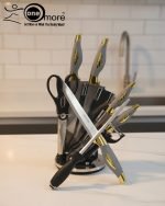 One More luxury 11-piece knife set in rotating stainless steel and clear acrylic block. Features black and gold accented handles, perfect as a modern kitchen centerpiece.