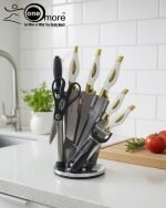 One More luxury 11-piece knife set in rotating stainless steel and clear acrylic block. Features black and gold accented handles, perfect as a modern kitchen centerpiece.