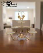 Luxurious gold tiered centerpiece serving stand with desserts and dry fruits on a coffee table. Ornate gold-plated serving tray for dry fruits and sweets. The Opulent Golden Tiered Serving Centerpiece
