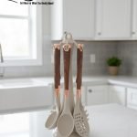 Luxury white marble-look cooking utensil set with rotating holder and rose gold accents. Includes spatula, spoon, and pasta server. Ideal kitchen decor centerpiece.