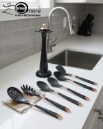 Luxury white marble-look cooking utensil set with rotating holder and rose gold accents. Includes spatula, spoon, and pasta server. Ideal kitchen decor centerpiece.