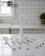 Luxury white marble-look cooking utensil set with rotating holder and rose gold accents. Includes spatula, spoon, and pasta server. Ideal kitchen decor centerpiece.