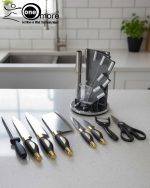 One More luxury 11-piece knife set in rotating stainless steel and clear acrylic block. Features black and gold accented handles, perfect as a modern kitchen centerpiece.