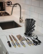 One More luxury 11-piece knife set in rotating stainless steel and clear acrylic block. Features black and gold accented handles, perfect as a modern kitchen centerpiece.