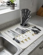 One More luxury 11-piece knife set in rotating stainless steel and clear acrylic block. Features black and gold accented handles, perfect as a modern kitchen centerpiece.