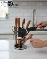 One More luxury 11-piece knife set in rotating stainless steel and clear acrylic block. Features black and gold accented handles, perfect as a modern kitchen centerpiece.