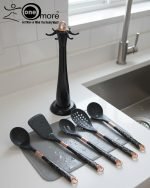 Luxury white marble-look cooking utensil set with rotating holder and rose gold accents. Includes spatula, spoon, and pasta server. Ideal kitchen decor centerpiece.