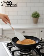 Luxury white marble-look cooking utensil set with rotating holder and rose gold accents. Includes spatula, spoon, and pasta server. Ideal kitchen decor centerpiece.