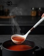 Luxury white marble-look cooking utensil set with rotating holder and rose gold accents. Includes spatula, spoon, and pasta server. Ideal kitchen decor centerpiece.