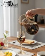 Elegant 7-piece glass water set by One More featuring one amber glass pitcher and six matching goblets, all decorated with a black and gold tulip design.