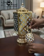 Fancy gold-tone beverage dispenser set with six matching stemmed goblets. The dispenser and glasses have a repeating geometric lattice pattern available in white and gold, blue and gold, or red and gold.