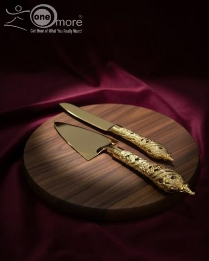 Gold-plated cake knife and server set with ornate handles, shown cutting a white birthday cake, a chocolate wedding cake slice, and displayed on a wooden board with a velvet BG. Elegant serving utensils.