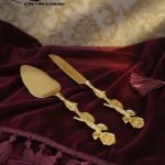 Gold-plated cake knife and server set with ornate handles, shown cutting a white birthday cake, a chocolate wedding cake slice, and displayed on a wooden board with a velvet BG. Elegant serving utensils.
