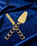 Gold-plated cake knife and server set with ornate handles, shown cutting a white birthday cake, a chocolate wedding cake slice, and displayed on a wooden board with a velvet BG. Elegant serving utensils.