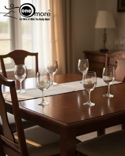 7-piece glass water set, including a clear glass jug/pitcher with white lid and six stemmed wine glasses, all featuring an elegant gold floral design, shown serving beverages in a home setting.