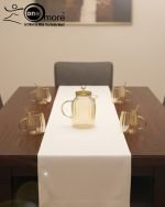 Full 7-piece amber glass water or tea set displayed on a wooden dining table with place mats and six matching cups.
