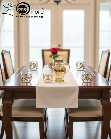 Elegant 7-piece glass beverage set with gold accents including a decanter and six tumblers, shown on a table setting and being used to pour a golden drink.