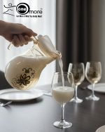 Elegant 7-piece glass water set by One More featuring one amber glass pitcher and six matching goblets, all decorated with a black and gold tulip design.