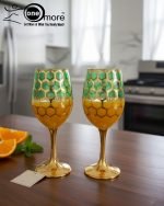 Fancy gold-tone beverage dispenser set with six matching stemmed goblets. The dispenser and glasses have a repeating geometric lattice pattern available in white and gold, blue and gold, or red and gold.