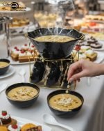 A complete 15-piece ceramic soup set displayed in a kitchen setting, featuring one large scalloped serving bowl, six small individual soup bowls, a golden metal storage stand, and seven white serving spoons. The set is available in six colors: black, dark gray-blue, navy blue, emerald green, beige/nude, and light mint green, all highlighted with an elegant gold rim.