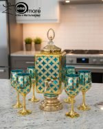 Fancy gold-tone beverage dispenser set with six matching stemmed goblets. The dispenser and glasses have a repeating geometric lattice pattern available in white and gold, blue and gold, or red and gold.