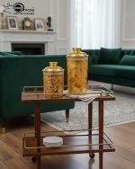 A set of three ribbed acrylic storage jars in different sizes, some with clear lids and some with shiny gold lids, filled with various nuts and snacks, displayed on a wooden table.