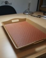 Set of three nesting fiber serving trays with non-slip textured surfaces and cut-out handles, displayed on a wooden dining table. The available colors are black, dark brown, grey, off-white, and rust-brown.