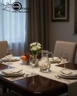 7-piece glass water set, including a clear glass jug/pitcher with white lid and six stemmed wine glasses, all featuring an elegant gold floral design, shown serving beverages in a home setting.