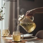 Full 7-piece amber glass water or tea set displayed on a wooden dining table with place mats and six matching cups.