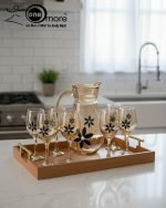 Elegant 7-piece glass water set by One More featuring one amber glass pitcher and six matching goblets, all decorated with a black and gold tulip design.