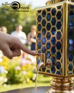 Fancy gold-tone beverage dispenser set with six matching stemmed goblets. The dispenser and glasses have a repeating geometric lattice pattern available in white and gold, blue and gold, or red and gold.