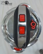 Top-down view of the O.M.S. Callacook 5-Litre Turkish pressure cooker lid. The lid features a sleek stainless steel and black plastic housing with two prominent red push buttons for the unique, easy-to-use locking and unlocking mechanism. A separate red lever near the edge controls the advanced pressure valve, highlighting the high-quality, modern design and superior safety features of this premium, imported Turkish cooker.