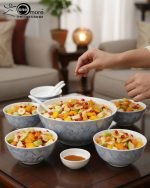 14-piece ceramic soup and ramen bowl set in four color variations: light blue, warm beige, sunset orange, and deep violet marble patterns, all including ceramic spoons and a large serving bowl.