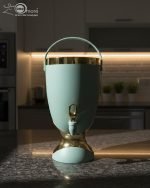 Insulated, stylish beverage dispenser (water cooler) with gold accents on base and spigot, shown in white, green, and chocolate/taupe colors, used for serving drinks on a dining table or kitchen counter.