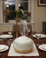 Luxury Royal buffet server set in black and gold color, a 6-liter chafing dish used for serving crispy fried shrimp at a formal dinner table, featuring an elegant golden stand and an overhead lid. The base includes a holder for canned heat or a buffet burner.