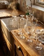 Pasabahce 7-piece glass water set featuring one clear jug and six stemmed glasses with elegant gold rims, displayed on a wooden surface.