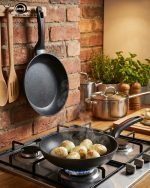 One More 24cm non-stick granite fry pan with silicone handle cooking eggs on a stovetop, featuring durable granite coating for low-oil cooking.