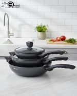 One More 24cm granite non-stick wok with glass lid and black silicon handle, displaying healthy low-oil cooking with fresh vegetables in the background.