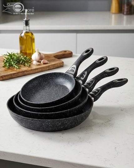 Stack of One More black granite non-stick cooking pots in four sizes (22cm, 24cm, 26cm, and 28cm) with ergonomic handles, displaying a premium speckled texture.