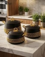 Three-piece luxury insulated hotpot set by One More in matte black and pearl white, featuring gold honeycomb lattice designs, gold handles, and steaming hot food in various dining settings.