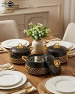 Three One More branded insulated hotpots in black and white marble finishes with gold honeycomb detailing and gold handles, shown in a kitchen and dining room setting with steaming food.