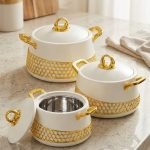 Three-piece luxury insulated hotpot set by One More in matte black and pearl white, featuring gold honeycomb lattice designs, gold handles, and steaming hot food in various dining settings.
