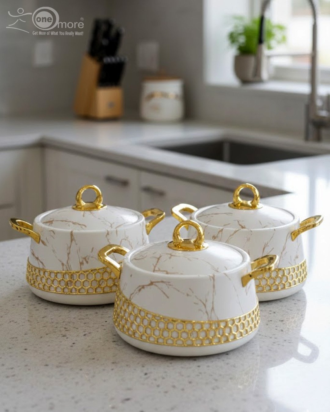 1.1 Three One More branded insulated hotpots in black and white marble finishes with gold honeycomb detailing and gold handles, shown in a kitchen and dining room setting with steaming food.