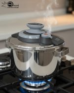 6-liter stainless steel pressure cooker made in Turkey with silver handles, shown steaming on a gas stovetop with fresh vegetables.