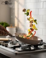 O.M.S premium granite non-stick fry pan made in Turkey, shown cooking vegetables with minimal oil usage and featuring a durable speckled beige finish.